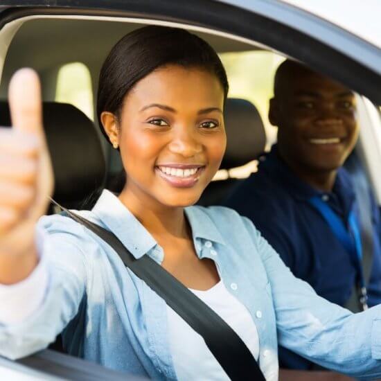 Young women learner driver having driving lesson with an approved driving instructor